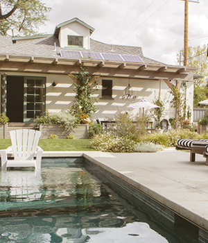 Wooden seats by a pool with parasols
